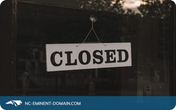 A black and white closed sign in the window of a business.
