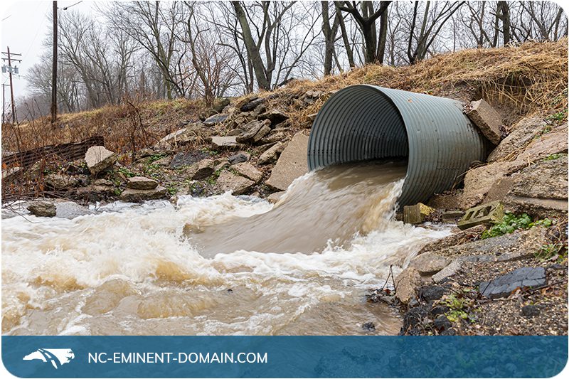 Stormwater rushing out of a culvert pipe after heavy rain.