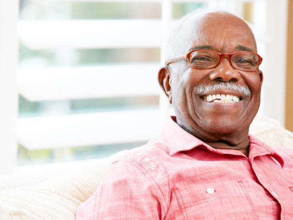 Man with red glasses smiling.