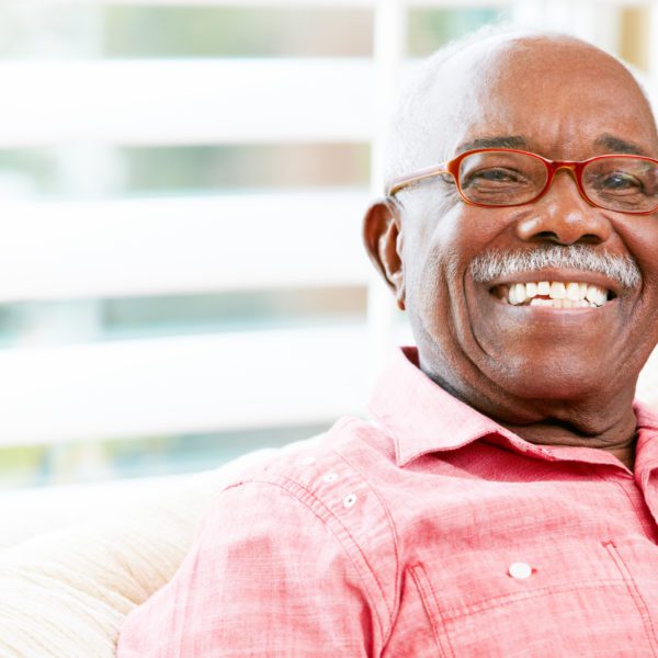 Man with red glasses smiling.