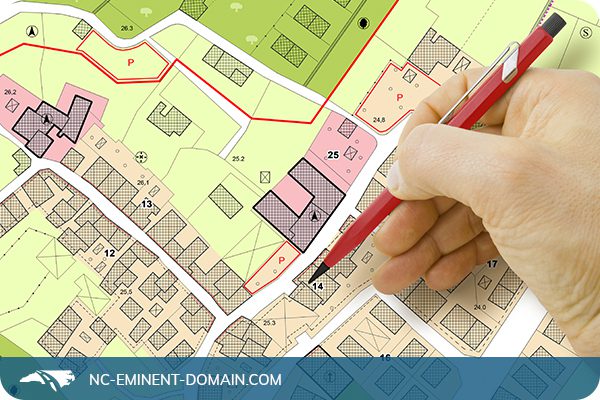 Engineer marking with pencil on a neighborhood planning map.