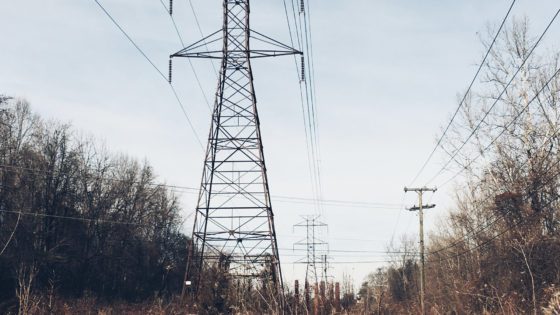 Electrical tower with phone and internet cables on a cloudy day.