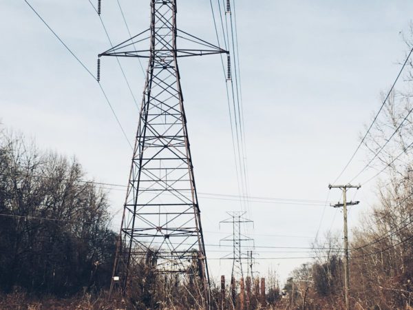 Electrical tower with phone and internet cables on a cloudy day.