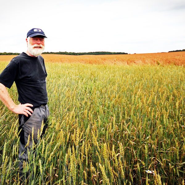 Famer smiling in a field.